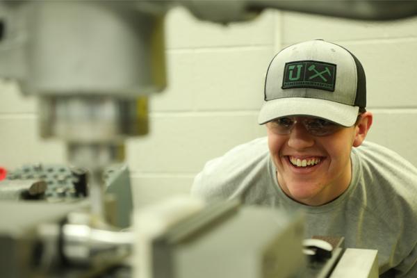 A student looking at precision machining equipment.